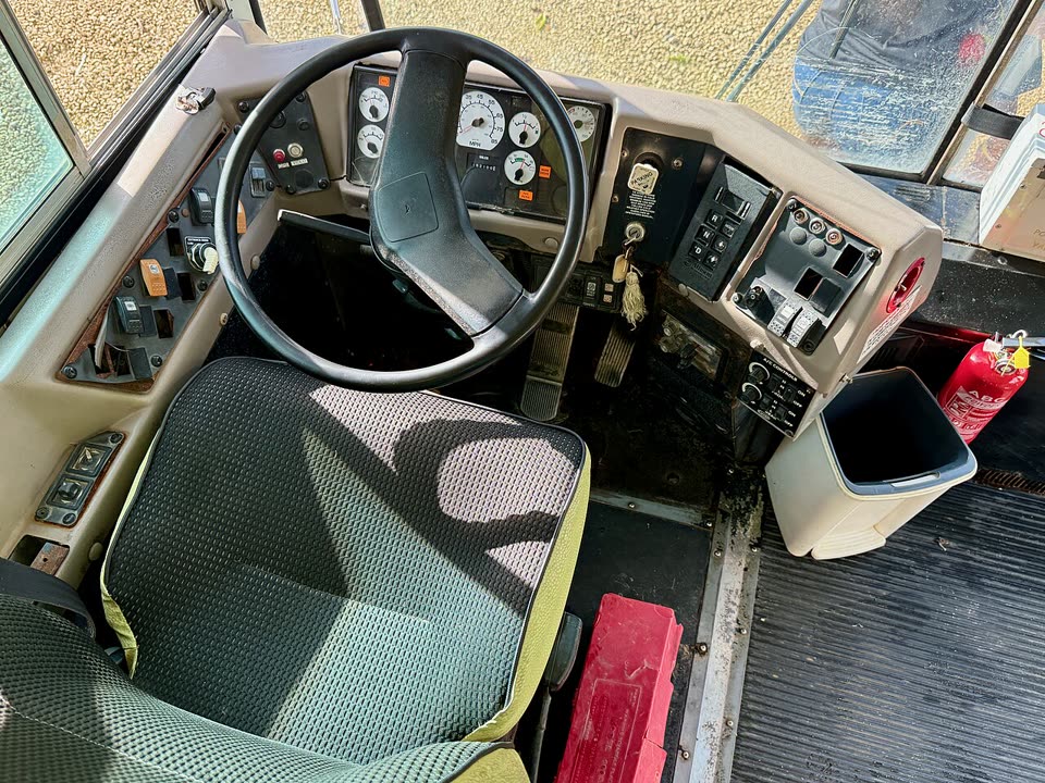 Driver's seat area inside a school bus, showing the steering wheel, mirrors, and driver controls.